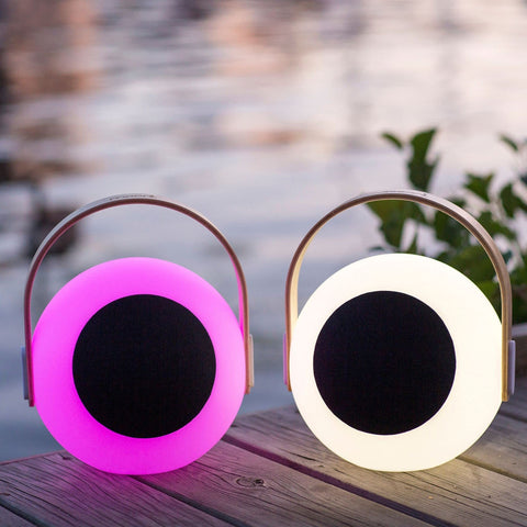Eye Color Changing LED Lantern With 10W Bluetooth Speaker, pink and white mood lamp on wooden deck by water.