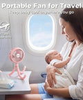 Battery Operated Stroller Fan With Flexible Tripod Clip On For Car Seat Crib Or Wagon on airplane table next to mother and baby