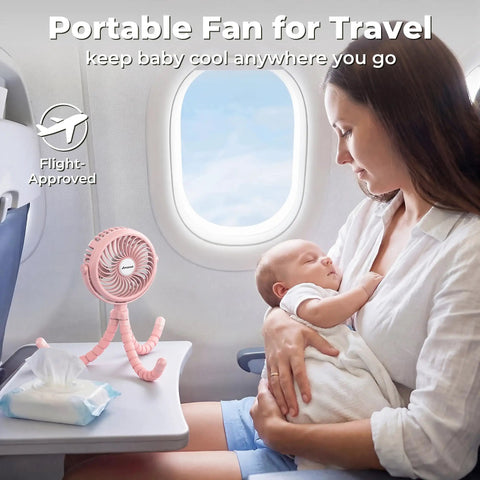 Battery Operated Stroller Fan With Flexible Tripod Clip On For Car Seat Crib Or Wagon on airplane table next to mother and baby