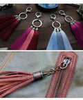Colorful tassel keychains with silver lobster claw clasps next to leather bag showcasing clasped cord end cap terminator.