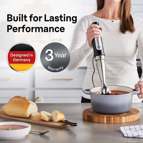 A woman using the Badass 3-In-1 Hand Blender And Food Processor Featuring Intuitive Smart Speed Tech for blending soup in a pot.