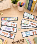 15 Piece Classroom Rules Posters And Greeting Cards Set with greetings like "High Five" and "Hug," on a desk with supplies