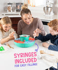Family using Ultimate Gummy Candy Making Kit For Home Use With Four Mold Shapes And Heating Base, syringes for filling.