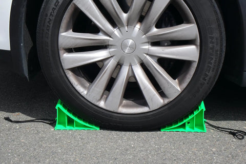 Heavy Duty Wheel Chocks Built Tough To Lock Your Rig Down Non Slip Safety Blocks For Rvs Trucks Trailers Campers Cars And Boats High Density Polypropylene Pair supporting a car tire on pavement.