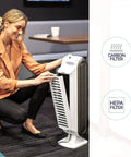 Woman adjusting AeraMax 100 Air Purifier With True HEPA Filter And Four Stage Purification in small room.