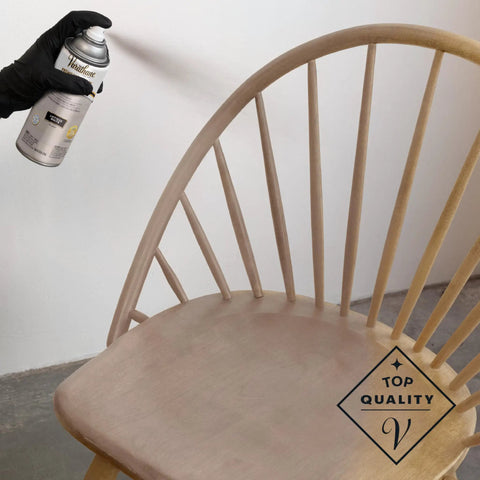 Applying Premium Antique White Oil Based Wood Stain Spray to a wooden chair, showcasing intricate areas and a smooth finish.