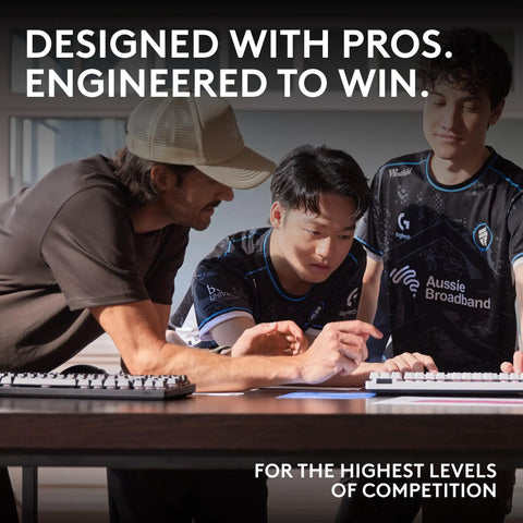Three gamers collaborating over a desk with a Compact Sixty Percent Wireless Gaming Keyboard Featuring Tactile Optical Switches And Sleek Magenta Build.
