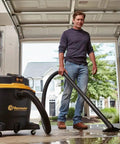 Man using Beast Series 16 Gallon Wet/Dry Shop Vac With 6.5 HP Motor, Beast Mode 360 Air Watts Suction in a garage setting.