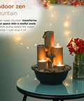 Indoor Tabletop Tiered Water Fountain With 3 Candles, 11 Inch Brown, on glass table with dim candlelight and red flowers.