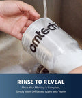 Person rinsing a metal cup marked with Premium Laser Marking Spray For Co2 And Fiber Engravers Delivers Knockout Contrast On Bare Metals With Quick Dry Formula For Seriously Dope Custom Creations Every Single Project Guaranteed.