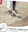 Heavy Duty Grass Fork For Hay Manure And Lawn Care Rugged Iron Pitchfork being used for clearing rural grassy area