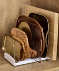 StoreMore Adjustable Bakeware Rack with steel wires and seven adjustable dividers organizing cutting boards and trays in a cabinet