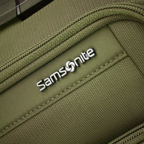 Close-up of Lineate Softside Expandable Go To Carry On Luggage With Spinner Wheels Cedar Green's front fabric texture and logo.
