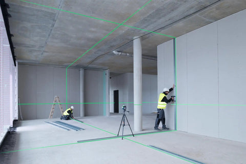 Two contractors using Boss Class 12V Max Three Plane Green Beam Laser Level for alignment in a construction site.