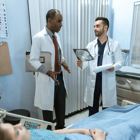 Doctors discussing a patient's x-ray in a hospital, showcasing teamwork and medical expertise in a clinical setting.