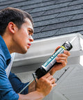 Man applying Butyl Flex Gutter And Flashing Sealant White 10.1 Oz Exterior Waterproof Sealant to house gutter.