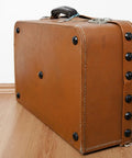 Solid 12 Pack Iron Clavos 1.5 Inches Long Featuring Gritty Hammered Black Finish on rustic brown suitcase.