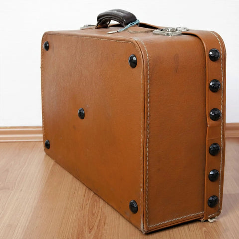 Solid 12 Pack Iron Clavos 1.5 Inches Long Featuring Gritty Hammered Black Finish on rustic brown suitcase.