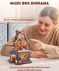 Hands-On DIY Miniature House Kit With Moving Scenes Music Box And LED Light, 3D Wooden Puzzles For Book Nook Tiny Home Decor, Kinetic Model Building Kit Type C Powered, Gift For Adults And Craft Lovers, woman pointing at toy shop diorama