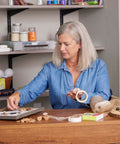 Woman using Double-Sided Craft Dots Half Inch Permanent Adhesive Points, 200 Clear Dots On Roll for a DIY project