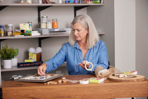 Woman using Double-Sided Craft Dots Half Inch Permanent Adhesive Points, 200 Clear Dots On Roll for a DIY project
