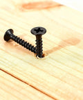 105 Piece Wood Screws Set With Black Oxide Finish And Phillips Drive, one screw partially installed in wood surface
