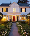 76 Inch Black Solar Lamp Post Light With Three Heads illuminating driveway of white house with garden