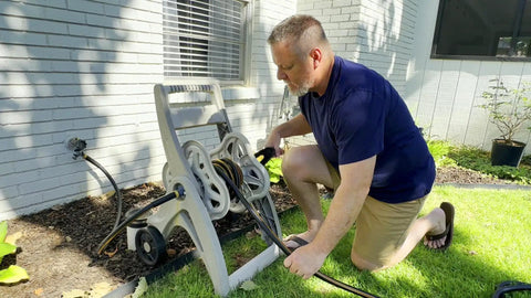 Man setting up Heavy Duty Garden Hose 5 Ft 5/8 Inch Female To Female Connector Black Water Hose with Short Leader Connection.