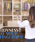 Person holding a white wire shelf divider with blurred closet backdrop, featuring 8 Pack White Wire Shelf Dividers For Closets On 12 Inch Shelves No Fuss Easy Install Closet Organizer Keeps Clothes Separated And Neat Ideal For Bedroom Bathroom Laundry And Small Space Storage.