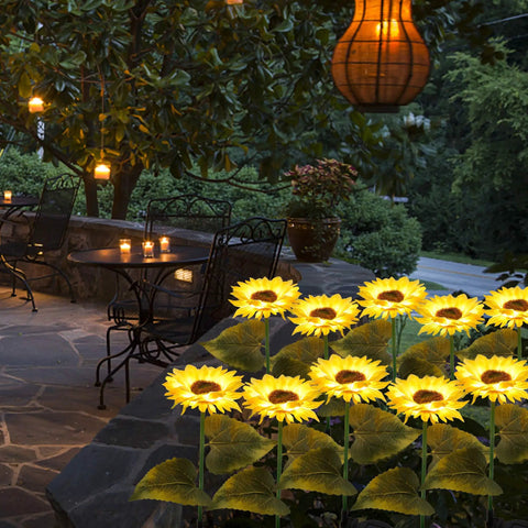 2 Pack Solar Garden Stake Lights Sunflower LED Pathway Lights in yard, glowing yellow with realistic fabric petals, weatherproof.