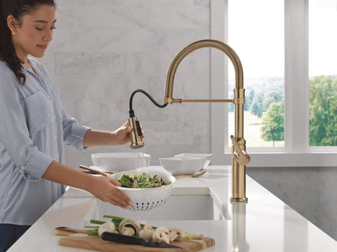 Woman using Pro Level Commercial Spring Neck Kitchen Faucet With Magnetic Docking Pull Down Sprayer Diamond Seal Tech in champagne bronze.