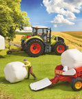 Scene with Claas Rollant 250 Round Baler Toy for Kids with tractors and workers on a farm, made from ABS plastic.