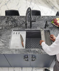 Man placing Silicone Bottom Grid Sink Mat For RVG1033 And RVG2033 Single Bowl Epigranite Sinks Gray in kitchen sink