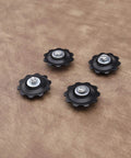 4X 10T Bicycle Gear Mech Pulley Jockey Wheel Kit Universal For 5,6,7,8 Speed Derailleur, black pulleys on brown background