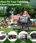 Portable Indoor Grill Table Stand For Ninja Woodfire OG701 OG850 OG951 Series 51 Inch Wide Folding Tailgating Table With 2 Wheels in a picnic setting.