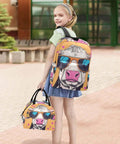 Child carrying a colorful backpack and lunch bag set with cow design, outdoors.