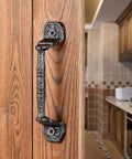 Four Pack Cast Iron Sliding Barn Door Handles 5.51 Inch Dark Brown Vintage Metal Pulls mounted on wooden door in kitchen