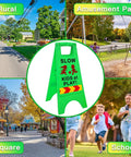 Slow Kids At Play Safety Sign 2 Pack Double Sided Text And Graphics Reflective Tape For Night Time Visibility in green urban setting