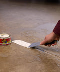 Heavy Duty Rubberized Waterproof Sealant Paste In Bright White Half Quart Tub being applied to seal a water leak on concrete floor.