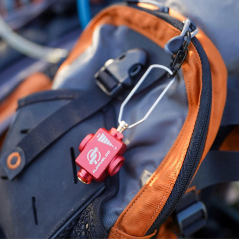 Fuel Transfer Kit For Backpacking And Camping With Flow Control Valve And Integrated Pressure Vent Isobutane Canister Refill Adapter clipped to backpack.
