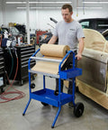Mobile 18 Inch Multi Roll Masking Paper Machine with storage trays in use at auto body shop by technician near car.