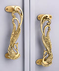 peacock decorative brass door handles in antique gold on cabinet