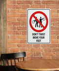 Dont Twist Move Your Feet Safety Instruction Sign 8x12 Aluminum on brick wall near table and chair