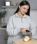 Fox Run stainless steel crinkle cutter with black handle slicing potato on cutting board.
