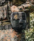 Side view of Rhino Rescue IFAK trauma kit MOLLE pouch in black attached to tactical vest.