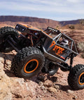 Capra UTB18 One Eighteenth Scale RC Crawler 4WD RTR on rocky terrain, highlighting tube chassis and portal axles in multicolor gray.