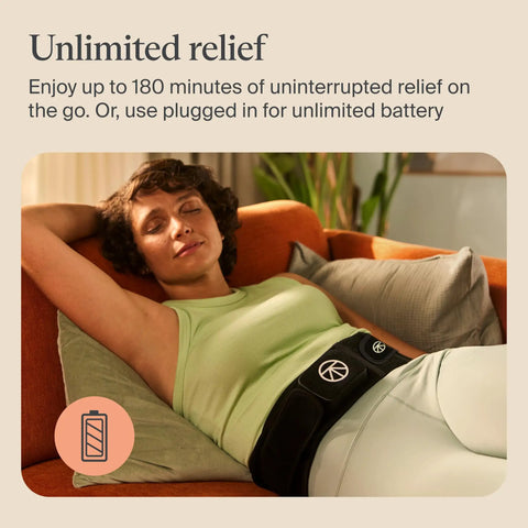 Woman relaxing on sofa wearing Four In One Back Wrap With Heat, Far Infrared, Vibration, And LED Therapy For Epic Lower Back Pain Relief At Home.