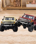 Two 1/12 scale RC crawler vehicles with upgraded metal chassis for heavy duty frame, shown in yellow and red, indoors.