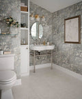 Elegant bathroom with floral wallpaper, round mirror, modern toilet, and partial view of Banbury 22.75 Inch Glass Shelf In Brushed Nickel With Tempered Glass Spot Resist Finish Includes Mounting Template Compatible With Banbury Faucets And Accessories Durable Bathroom Storage on the left.