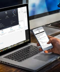 Person holding smartphone next to a laptop displaying Bootable USB Repair Kit For Windows PCs With Antivirus Data Recovery And Password Reset